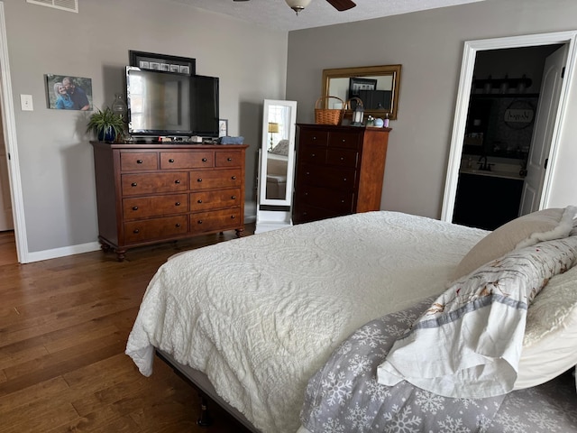 bedroom featuring visible vents, ceiling fan, baseboards, and wood finished floors