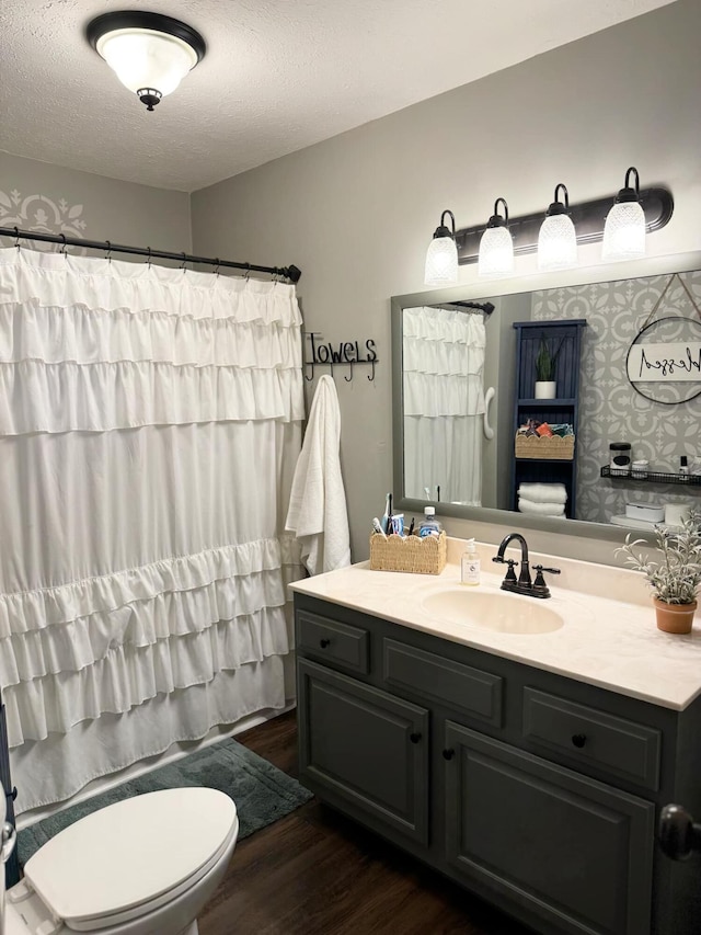 full bathroom with a textured ceiling, toilet, wood finished floors, vanity, and a shower with curtain