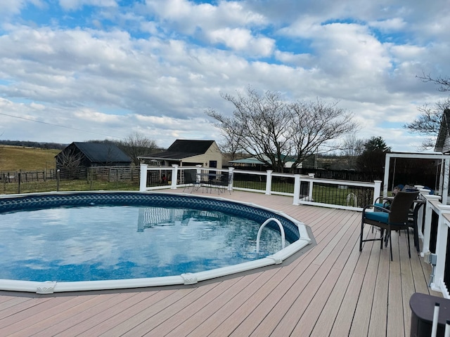 view of pool featuring a wooden deck, a fenced in pool, and fence