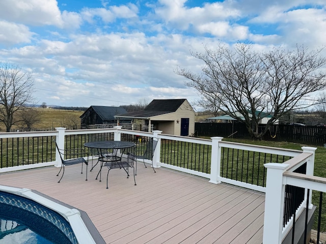 deck with a yard, outdoor dining space, an outdoor structure, and fence