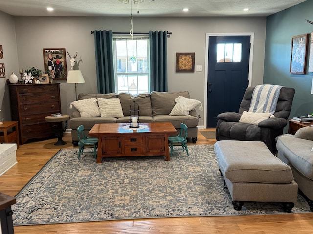 living room with a textured ceiling, wood finished floors, and recessed lighting