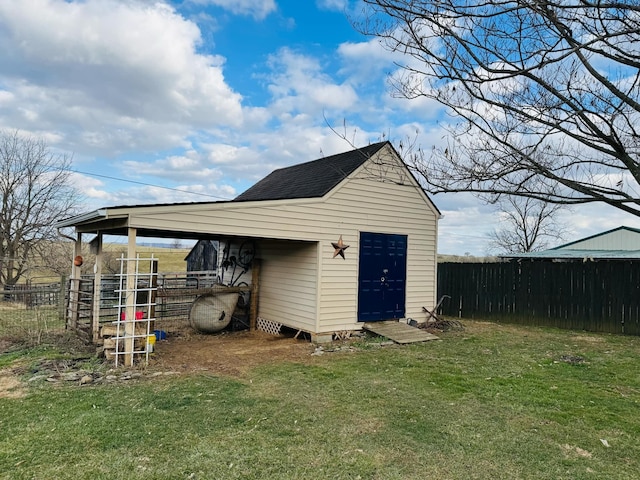 view of outbuilding with a carport, an outdoor structure, and fence