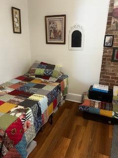 bedroom featuring baseboards and wood finished floors