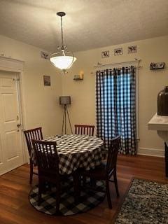 dining space featuring baseboards and wood finished floors