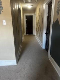 corridor featuring attic access, carpet, and baseboards