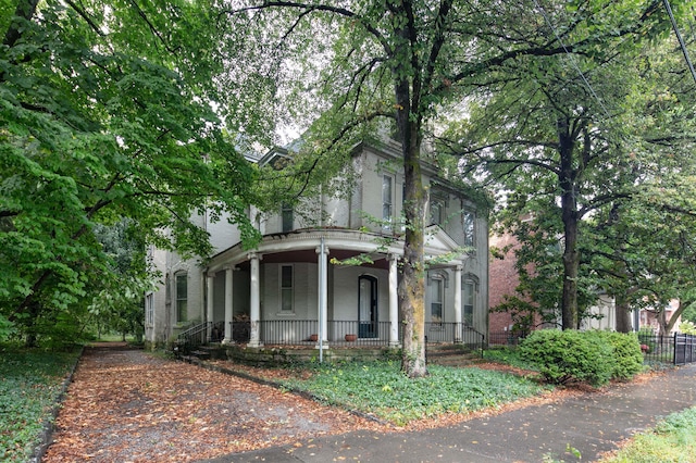 view of front of property featuring a porch and fence