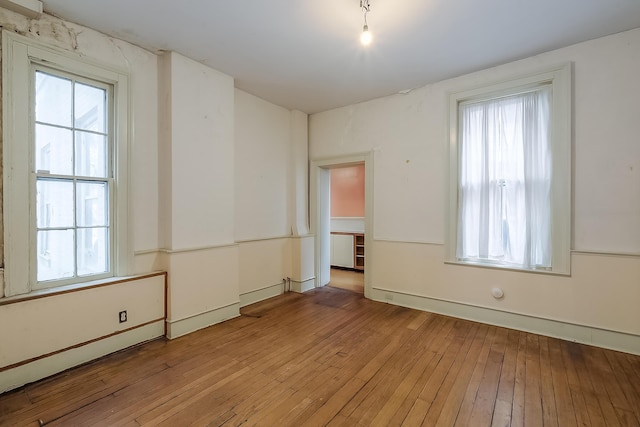 empty room featuring a wealth of natural light and light wood-style floors