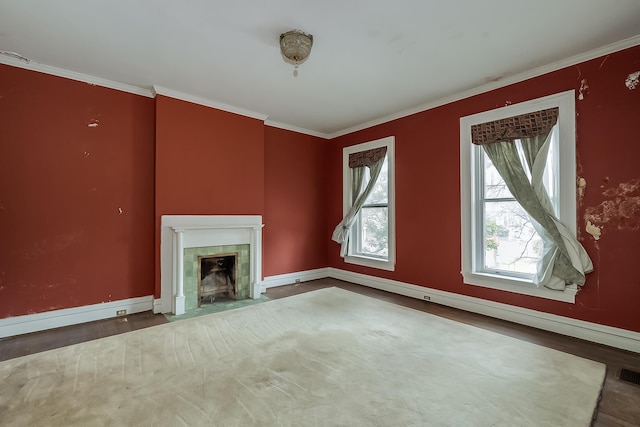 unfurnished living room with ornamental molding, a tile fireplace, visible vents, and baseboards