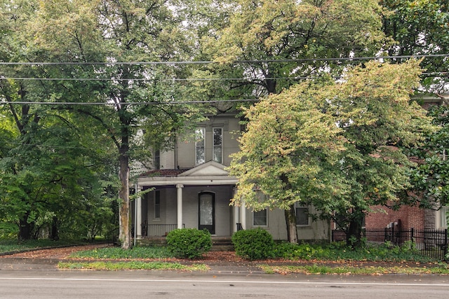 view of front of property featuring a porch and fence