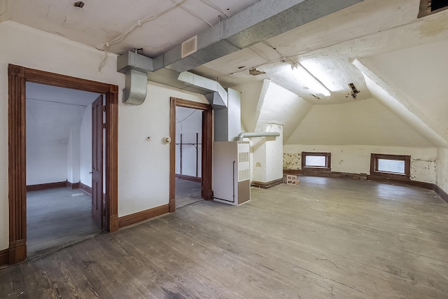 additional living space with lofted ceiling, visible vents, baseboards, and hardwood / wood-style flooring