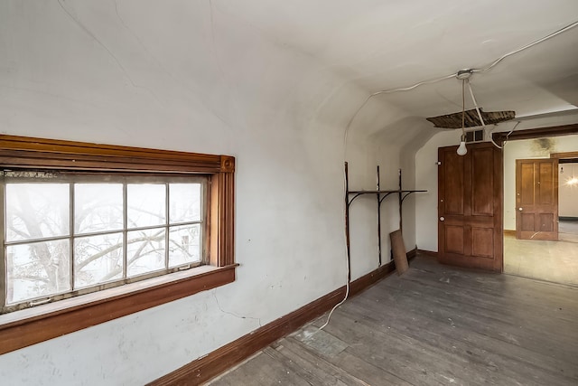 bonus room with wood-type flooring, visible vents, vaulted ceiling, and baseboards