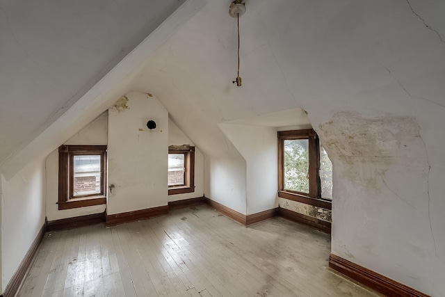 bonus room featuring baseboards, vaulted ceiling, and hardwood / wood-style floors