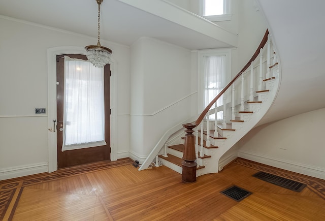 entryway with a chandelier, stairway, and visible vents