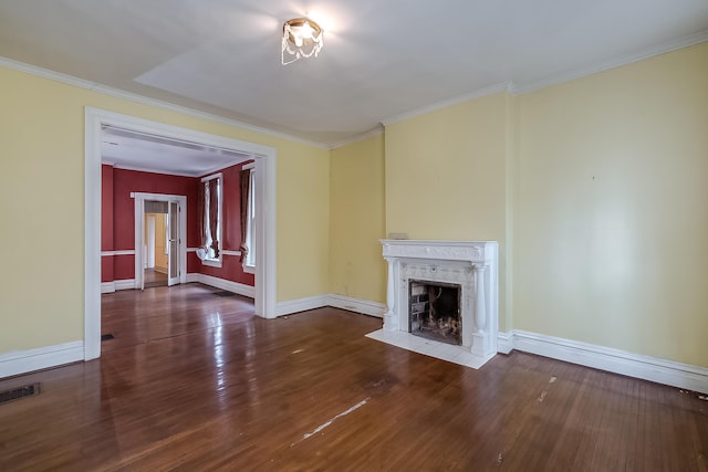 unfurnished living room with a fireplace, visible vents, ornamental molding, wood finished floors, and baseboards