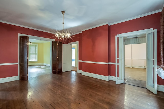 unfurnished room with hardwood / wood-style flooring, a notable chandelier, baseboards, and crown molding