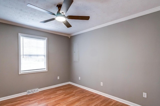 empty room featuring light wood finished floors, visible vents, ornamental molding, a textured ceiling, and baseboards