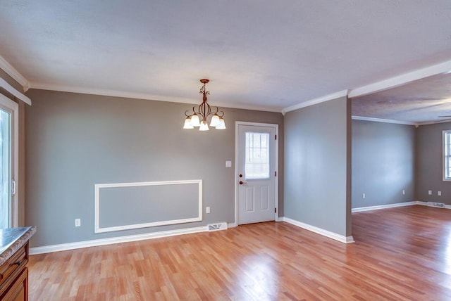 entrance foyer with baseboards, light wood-style flooring, visible vents, and an inviting chandelier