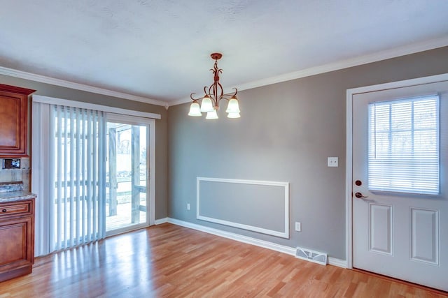 unfurnished dining area featuring ornamental molding, a wealth of natural light, light wood-style flooring, and visible vents