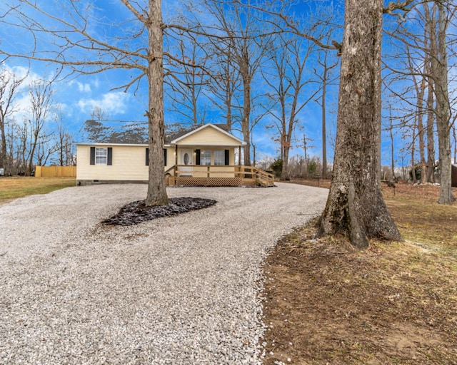 view of front of house featuring crawl space, covered porch, and gravel driveway