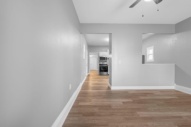 hallway featuring baseboards and wood finished floors