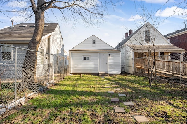 rear view of house featuring a lawn, entry steps, an outdoor structure, and a fenced backyard