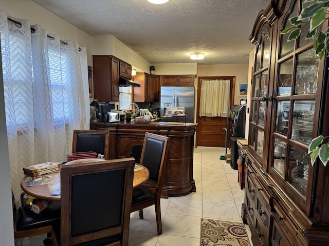 149 Cherokee Ave, Russell Springs, KY 42642 - kitchen featuring stainless steel fridge, light marble finish flooring, a textured ceiling, under cabinet range hood, and dark brown cabinetry