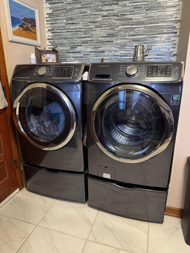 laundry room with laundry area, marble finish floor, and washing machine and clothes dryer