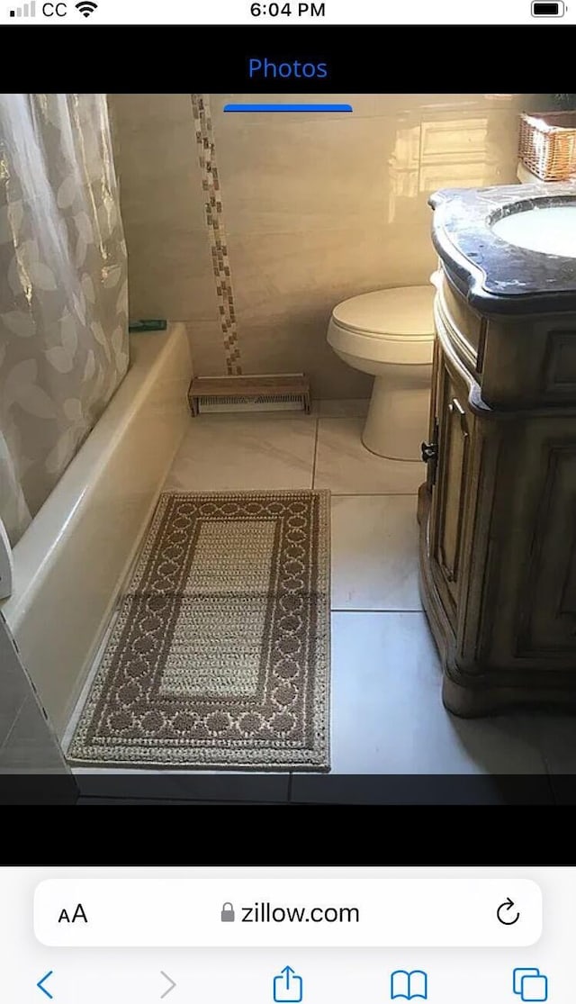 full bathroom featuring shower / tub combo with curtain, toilet, and vanity