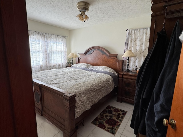 bedroom with light tile patterned floors and a textured ceiling