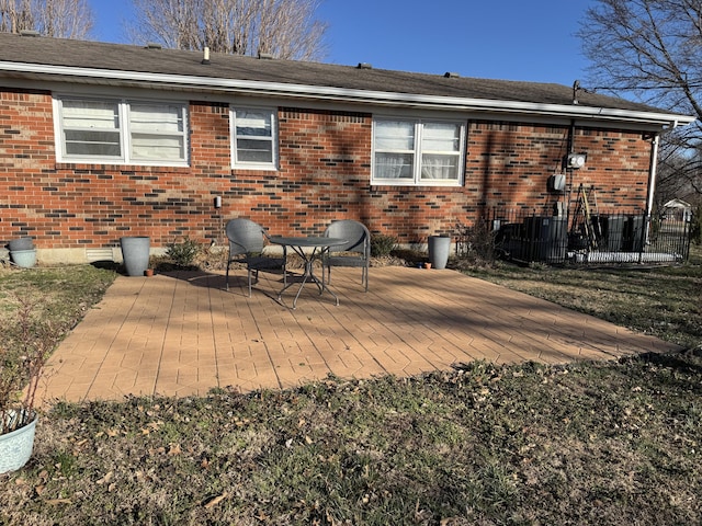 rear view of house featuring fence, brick siding, and a patio area