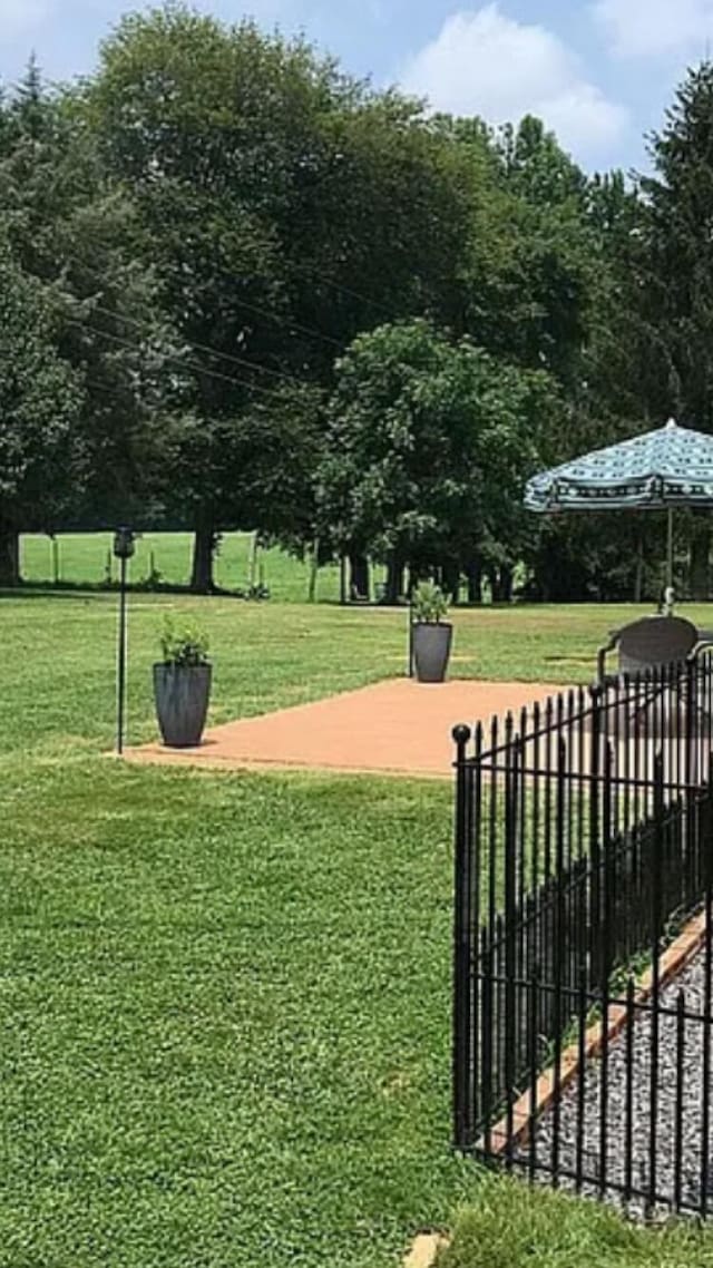 view of home's community with fence and a lawn