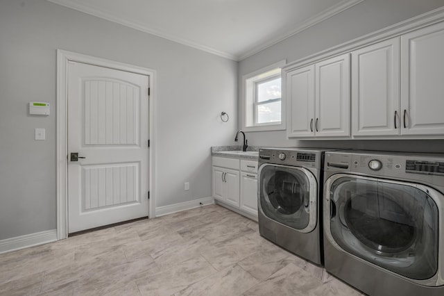 washroom with cabinet space, baseboards, crown molding, separate washer and dryer, and a sink