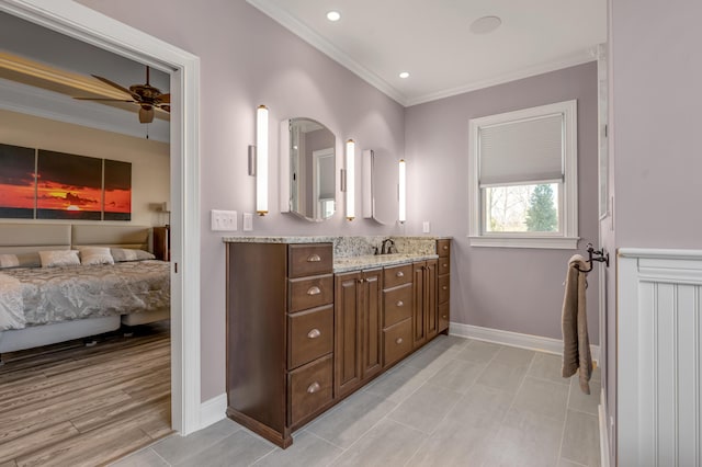 ensuite bathroom featuring a ceiling fan, baseboards, vanity, ensuite bath, and crown molding