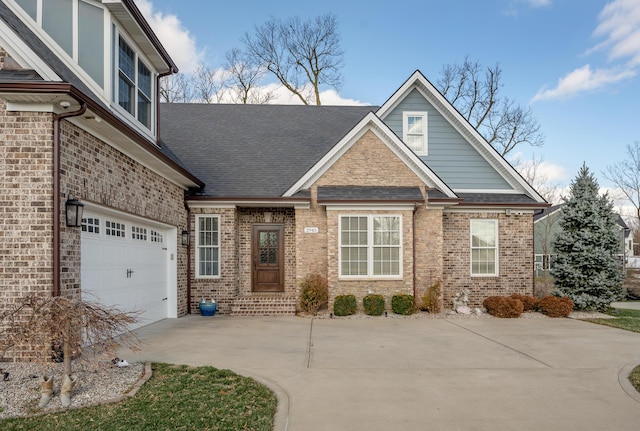 craftsman-style house featuring a garage, concrete driveway, brick siding, and roof with shingles