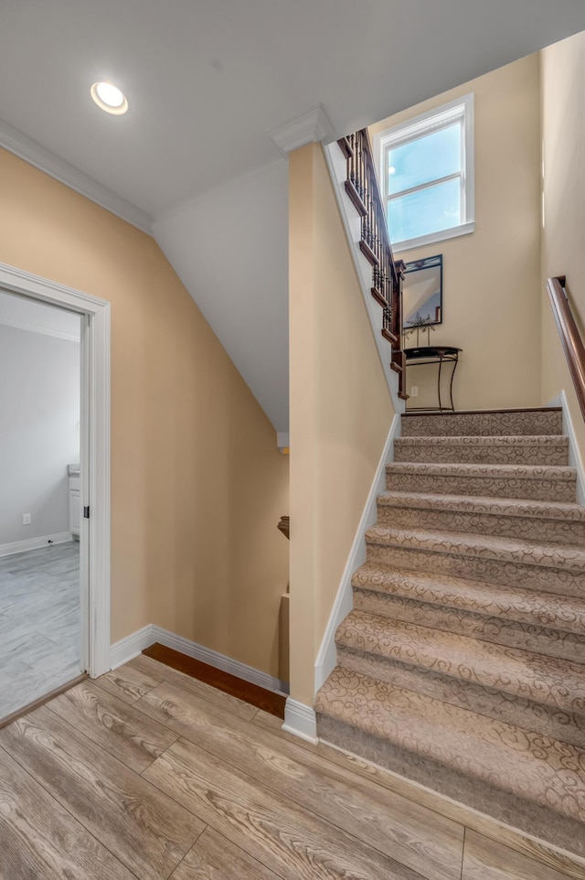 stairs with baseboards, wood finished floors, and recessed lighting