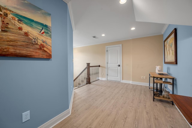 hallway featuring baseboards, ornamental molding, wood finished floors, and an upstairs landing