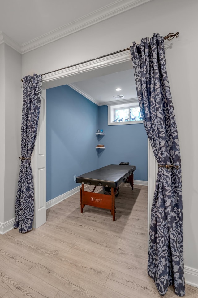 rec room with light wood-type flooring, baseboards, visible vents, and crown molding