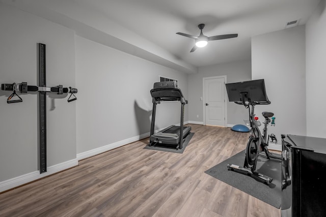 workout area with visible vents, wood finished floors, a ceiling fan, and baseboards