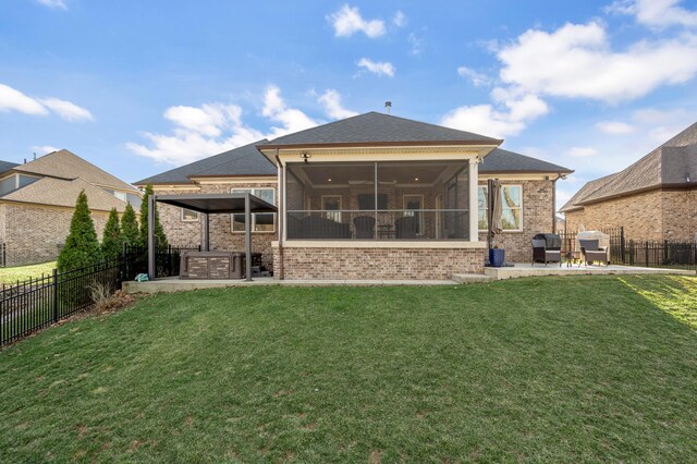 back of house featuring a lawn, a patio area, a fenced backyard, and a sunroom