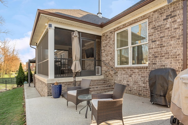 view of patio / terrace featuring a grill, a sunroom, and fence