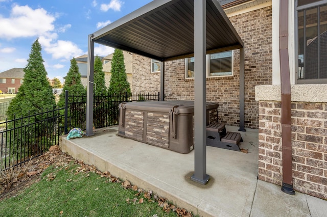 view of patio featuring fence and a hot tub