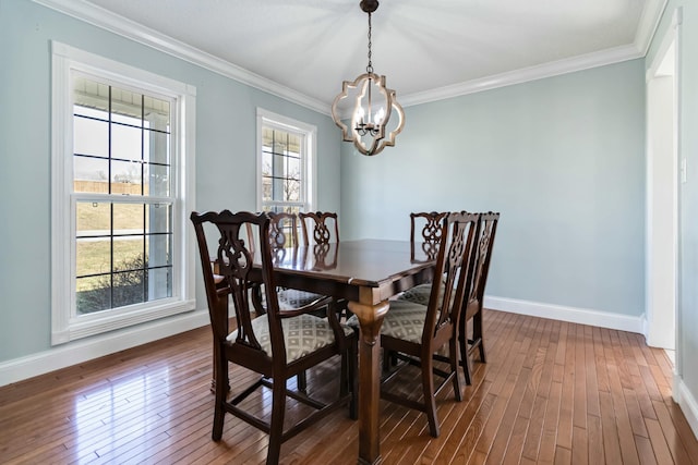 dining area featuring baseboards, ornamental molding, a chandelier, and dark wood-style flooring