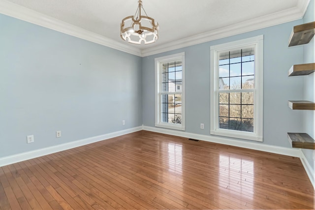 unfurnished room featuring a chandelier, visible vents, baseboards, ornamental molding, and wood-type flooring