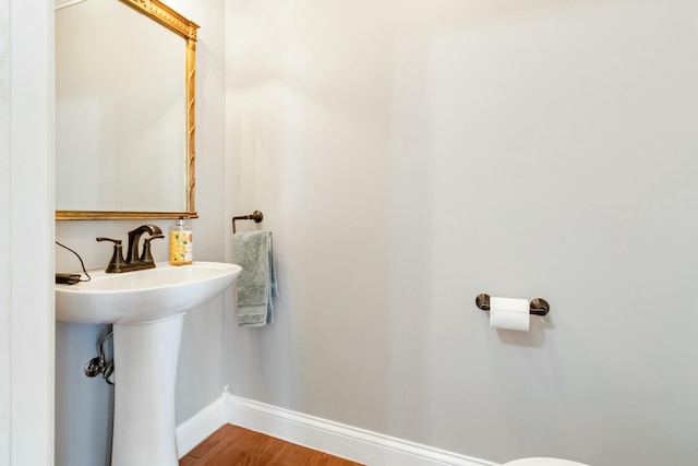 bathroom with baseboards and wood finished floors