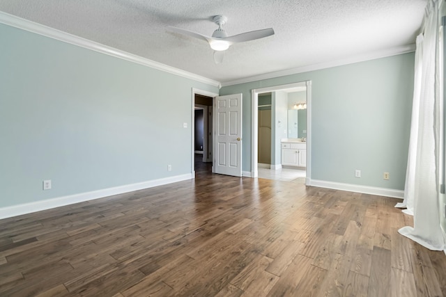 unfurnished bedroom with crown molding, a textured ceiling, baseboards, and dark wood-style flooring