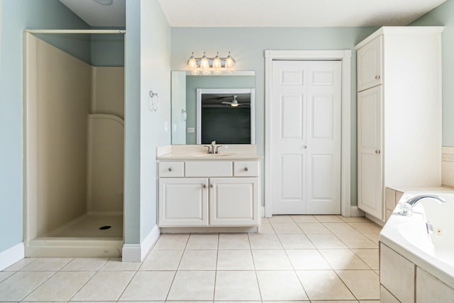 full bathroom with a stall shower, vanity, tile patterned flooring, baseboards, and a tub with jets