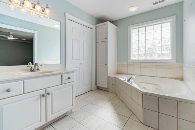 bathroom featuring a whirlpool tub, visible vents, vanity, and tile patterned floors