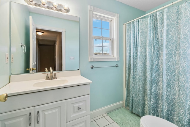 bathroom featuring baseboards, toilet, a shower with curtain, tile patterned floors, and vanity