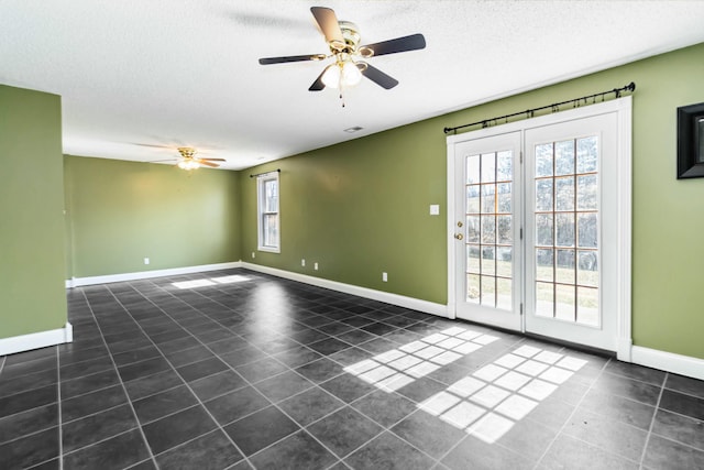 tiled spare room featuring a ceiling fan, a textured ceiling, and baseboards