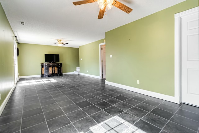 unfurnished living room featuring a ceiling fan, visible vents, and baseboards